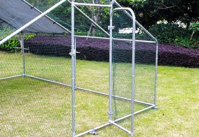 Close-up view of the 4x3m chicken run door featuring a secure locking system, with galvanised steel and wire mesh for backyard chooks.